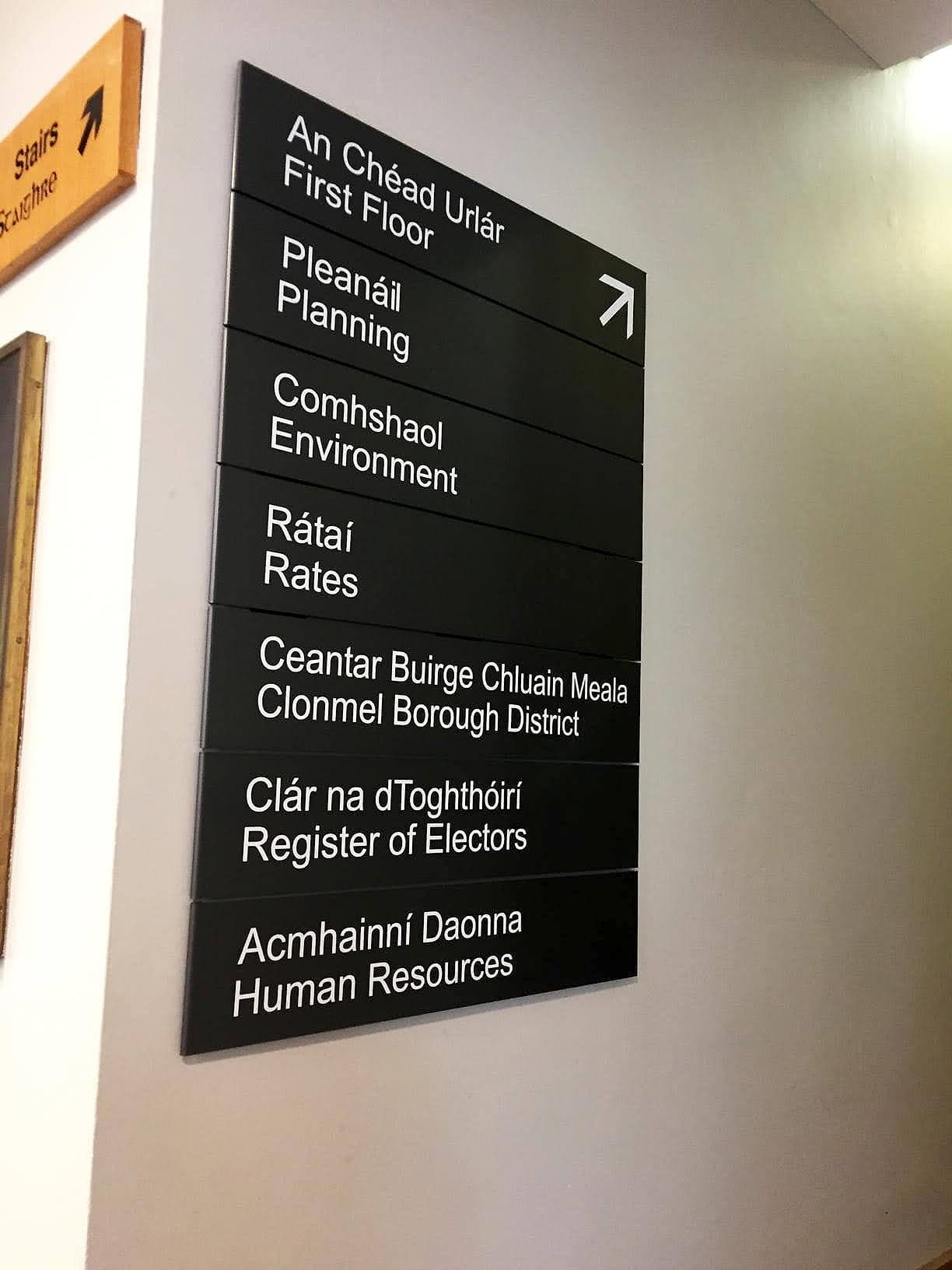 Bilingual Irish and English modular directory sign at Tipperary County Council offices, listing first-floor departments from Planning to Human Resources