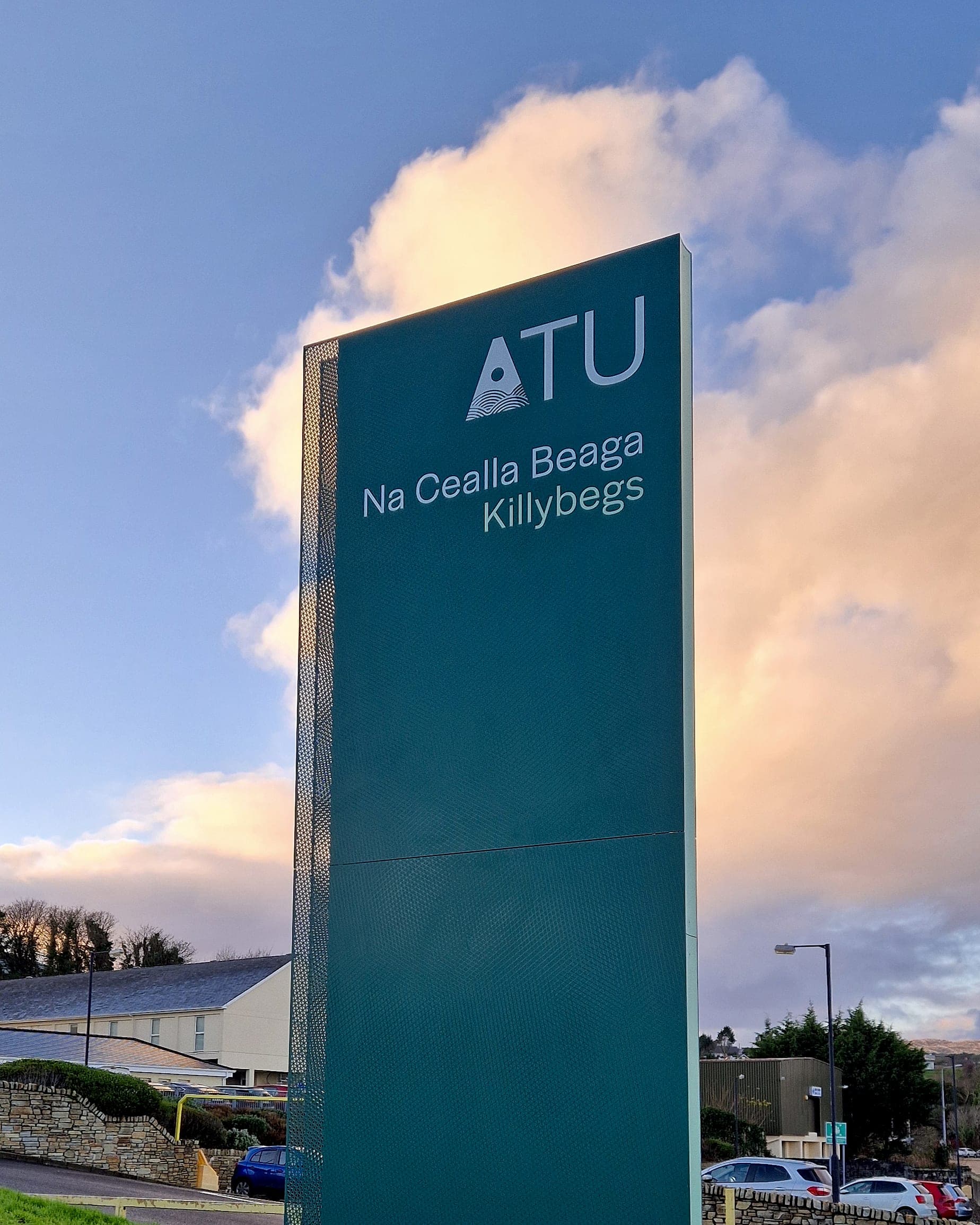 ATU Killybegs: external signage monolith at dusk on a campus entrance, its name panel still legible against a low winter sky