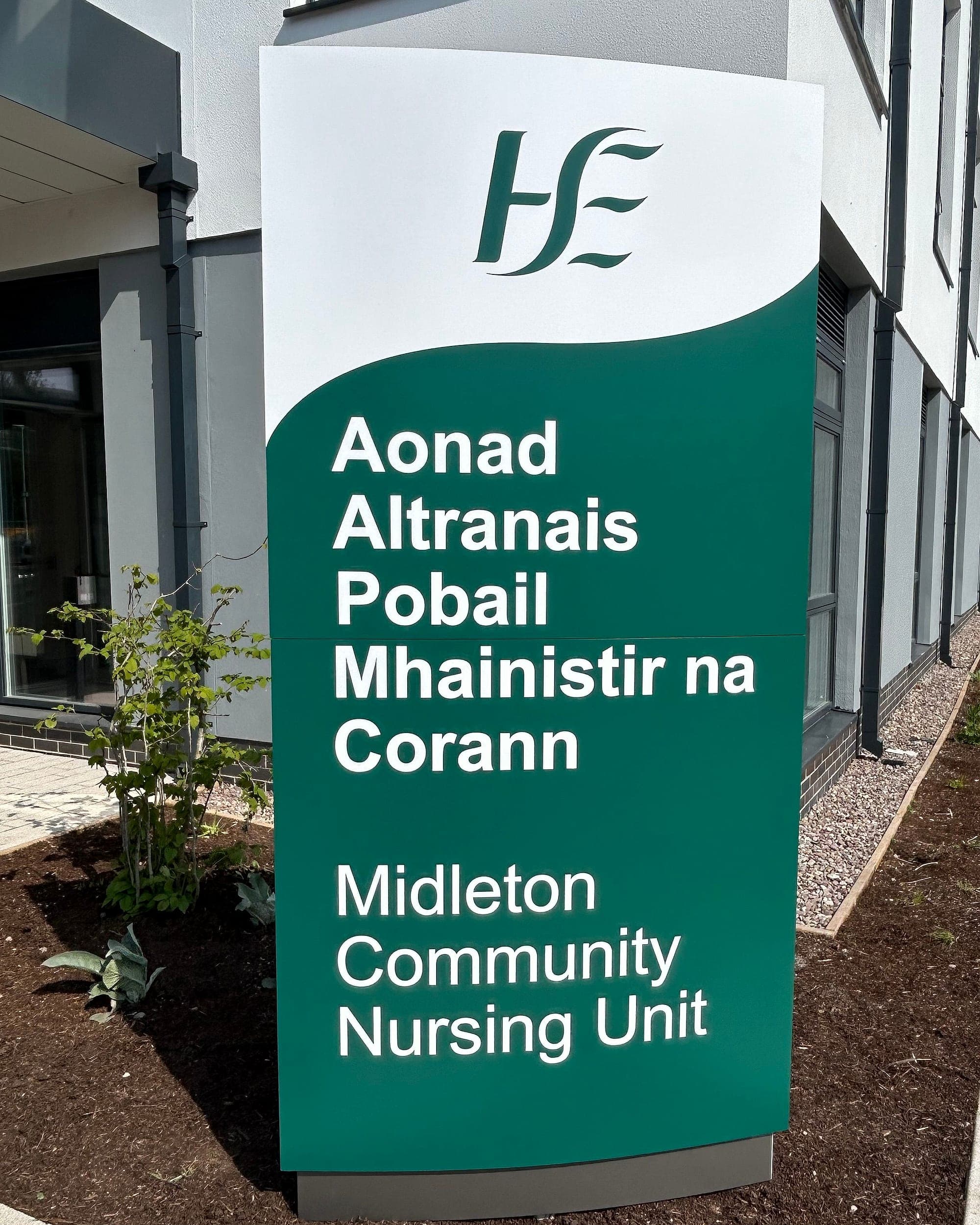 Bilingual identification totem for Midleton Community Nursing Unit, signage for elderly residents naming the building in Irish and English at the approach