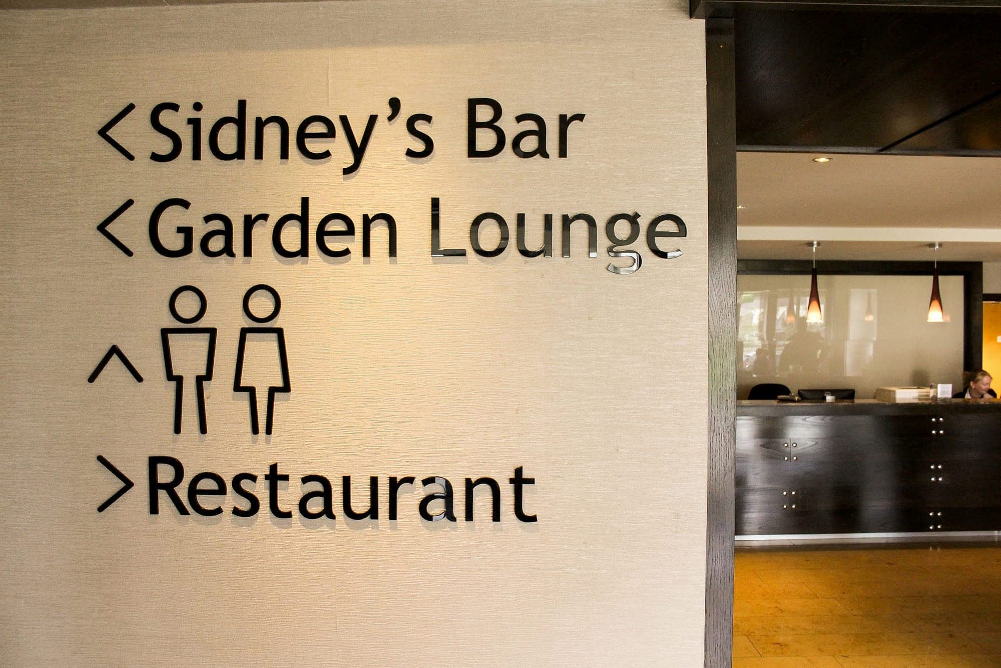 Individually cut gloss acrylic directional lettering for Sidney's Bar, Garden Lounge and Restaurant applied directly to a textured wall at Actons Hotel, with reception beyond