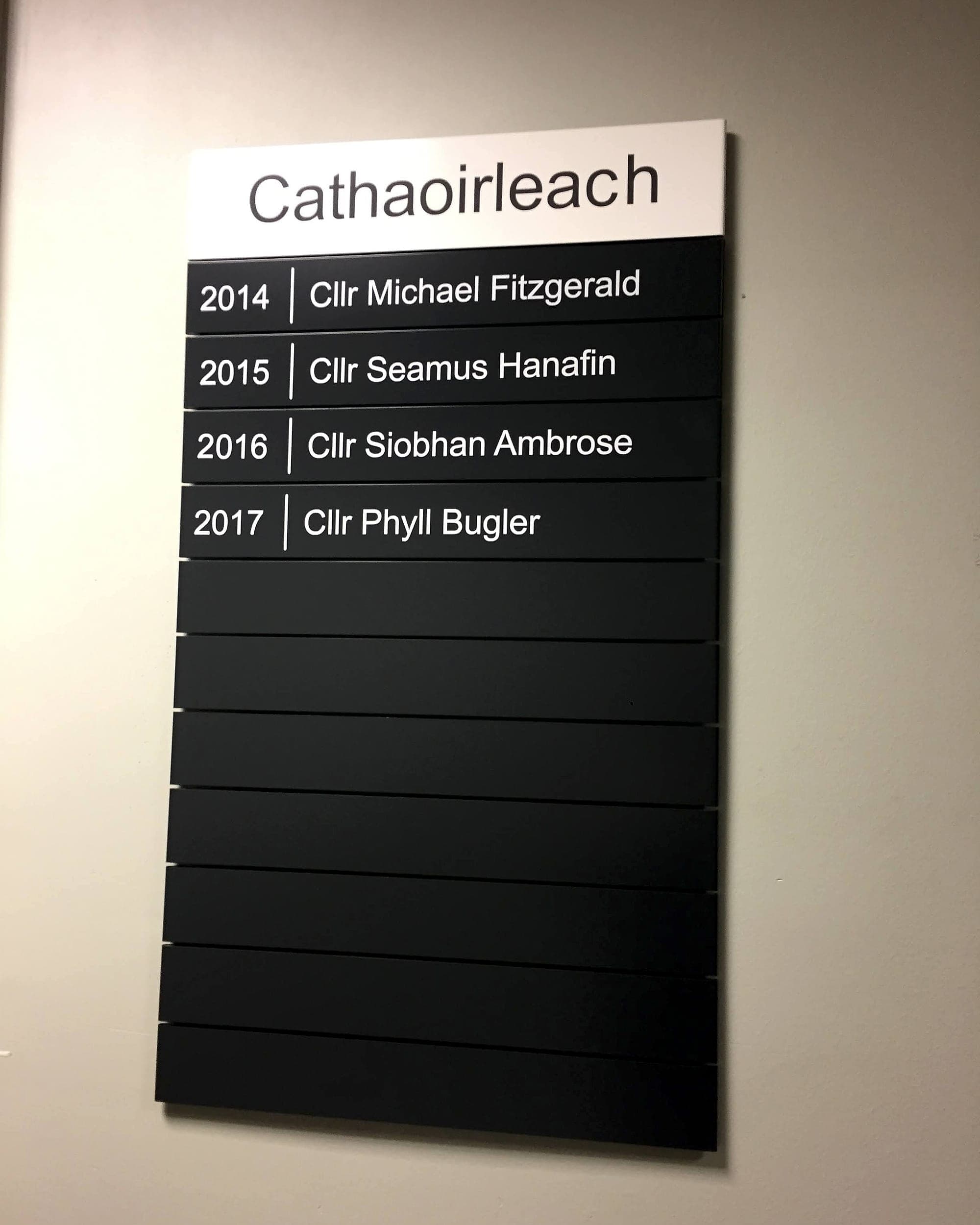 Static signage designed to be updated: a Cathaoirleach honours board for Tipperary County Council built as individual black slats, four years filled in and ten blank slats below waiting for future years