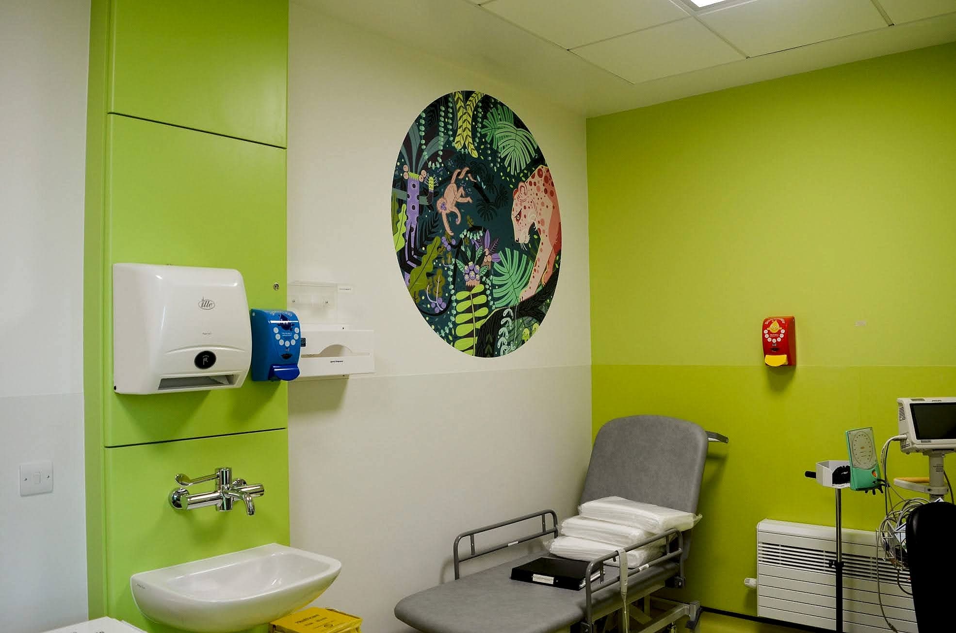 Clinical room at Temple Street Children's Hospital, Dublin: a circular jungle wall graphic of a jaguar and monkey on the wall facing the examination couch
