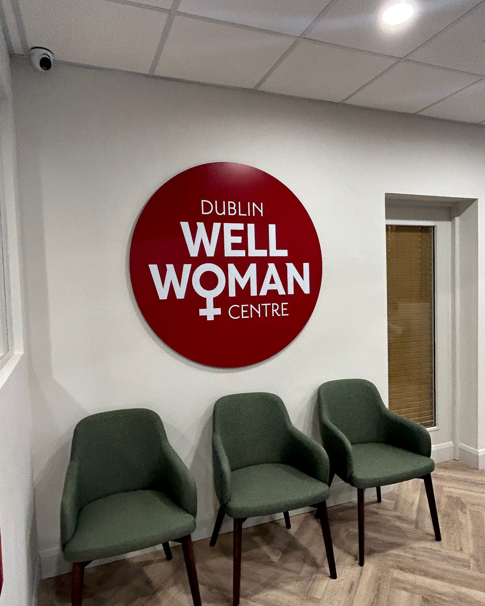 Clinic waiting room at the Dublin Well Woman Centre, Parliament Street, with a large circular identity sign above three chairs
