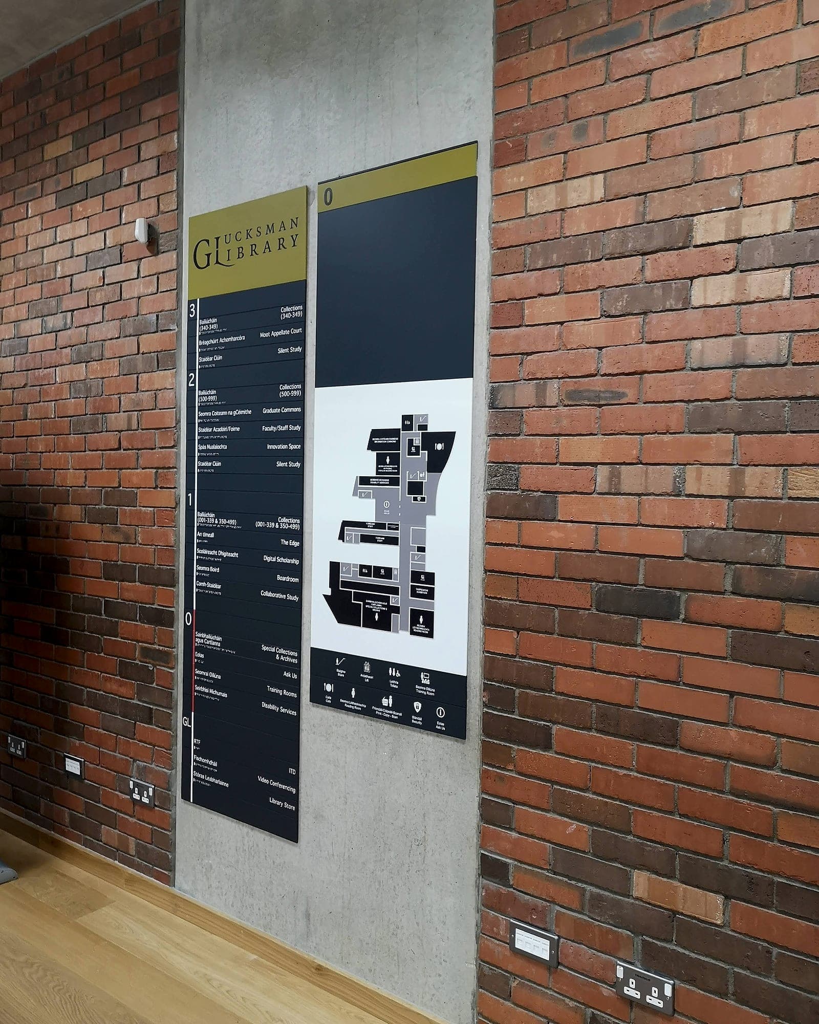 Static bilingual floor directory and you-are-here floor plan at the Glucksman Library, University of Limerick, mounted on a concrete pier in the library entrance, the information a digital wayfinding screen does not need to duplicate